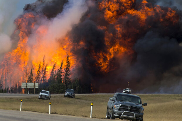 Photo of flames towering above the treeline near Fort McMurray on Saturday, May 7, 2016.