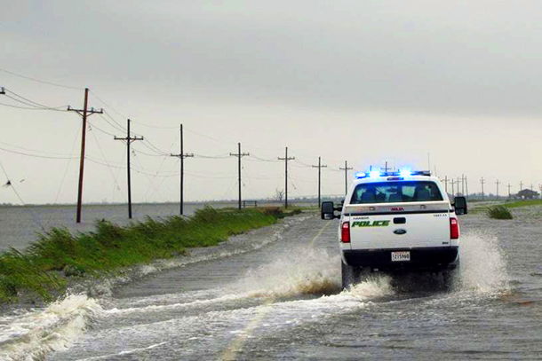 Police vehicle traveling down Highway 1 through ~8 inches of water