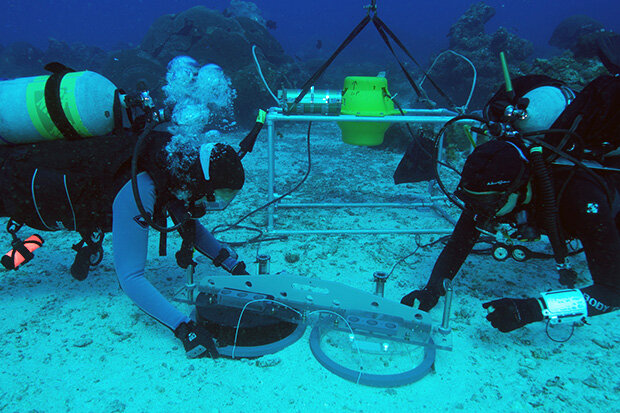 underwater photo of NOAA divers deploying a benthic chamber
