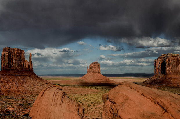 Photo of Monument Valley, Arizona, with a thunderstorm cloud
