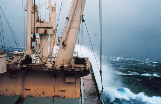 Ship with waves crashing over the bow