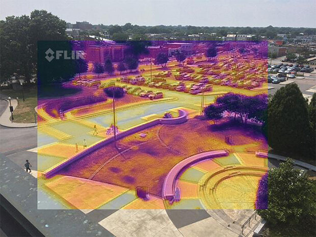Photo of a parking lots and surrounding areas with an overlay false-color image from a thermal IR camera