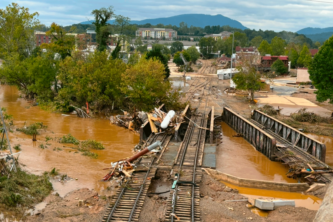 destroyed railroad bridge and mud-covered streets in Asheville, NC
